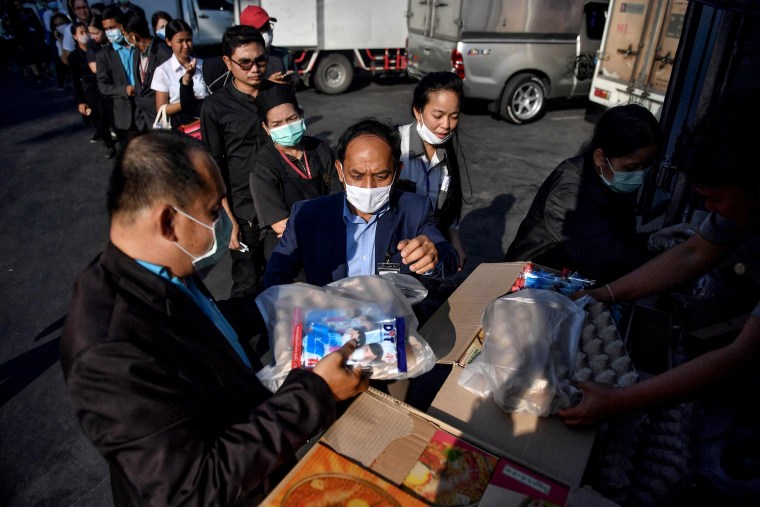 Image: People line up to buy face masks and discounted goods, like cooking oil and eggs, during the launch of the government's mobile caravan in Bangkok, Thailand, on March 5, 2020.