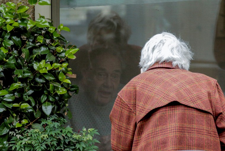 Image: Gene Campbell speaks to his wife of more than 60 years, Dorothy, at the Life Care Center of Kirkland on Thursday.