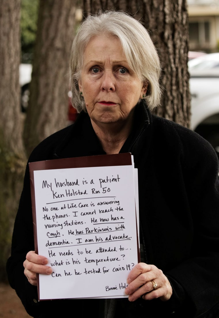 Image: Bonnie Holstad holds a sign expressing concern for her husband, Ken Holstad, who is a resident at Life Care Center of Kirkland, the long-term care facility linked to the two of three confirmed coronavirus cases in the state, in Kirkland, Washington