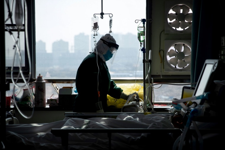 Image: A medical staff member treats a patient infected with coronavirus at a hospital in Wuhan on Feb. 22, 2020.