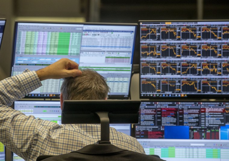 Image: A broker scratches his head as he looks at his screens at the stock market in Frankfurt, Germany,