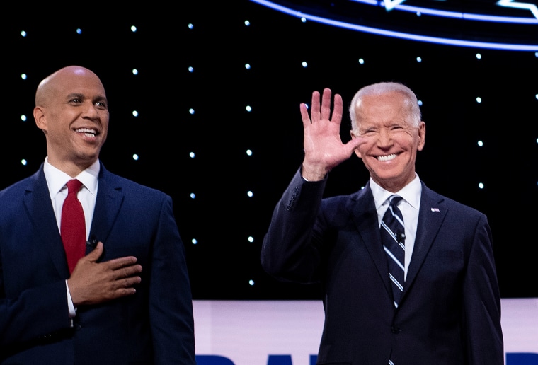 Sen. Cory Booker and former Vice President Joe Biden take the stage ahead of a Democratic debate in Detroit on July 31, 2019.
