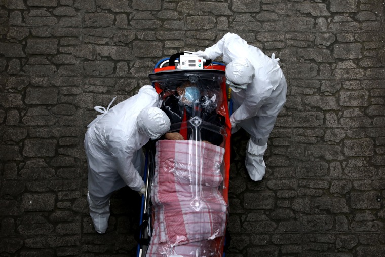 Image: Medical staff move a patient infected with coronavirus from an ambulance to a hospital in Seoul, South Korea, on Monday.  According to the Korea Centers for Disease Control and Prevention, 69 new cases were reported on Monday, with the death toll r