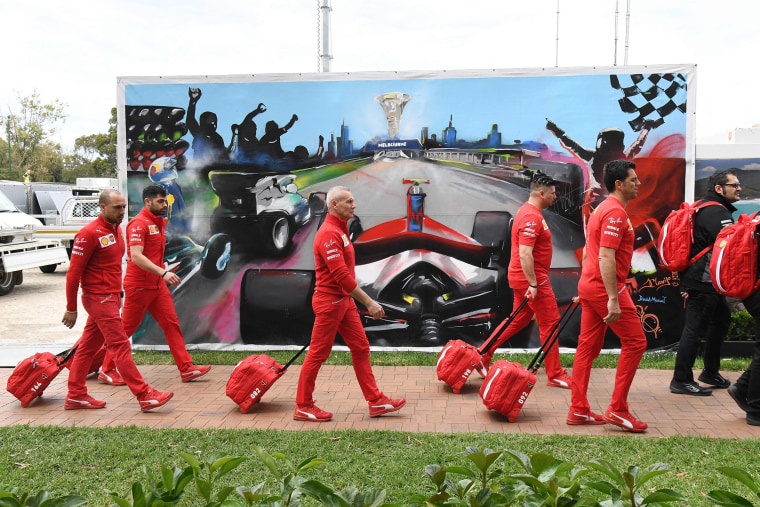 Image: Members of the Ferrari team arrive to pack up their equipment after the Formula One Australian Grand Prix was canceled in Melbourne