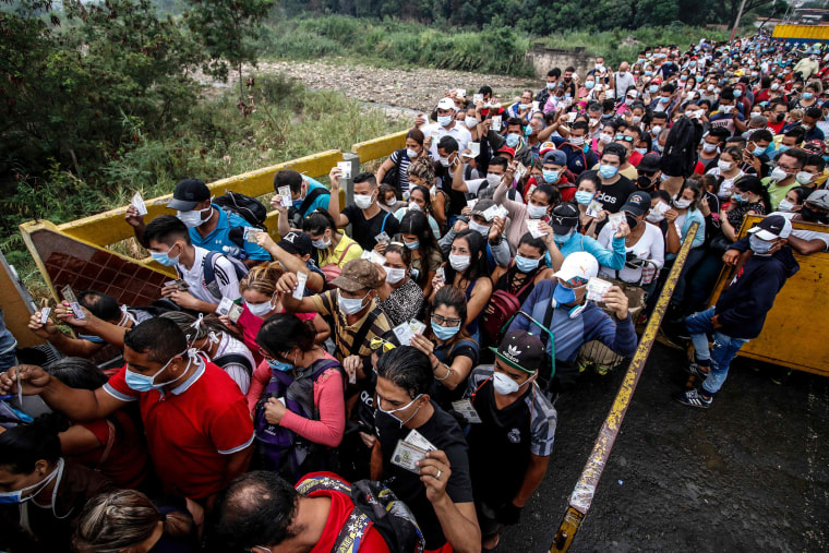 Image: People coming from Venezuela with protective face masks as a precautionary measure to avoid contracting the new coronavirus, COVID-19, show hold their documents on the border at Simon Bolivar International Bridge, in Cucuta, Colombia,