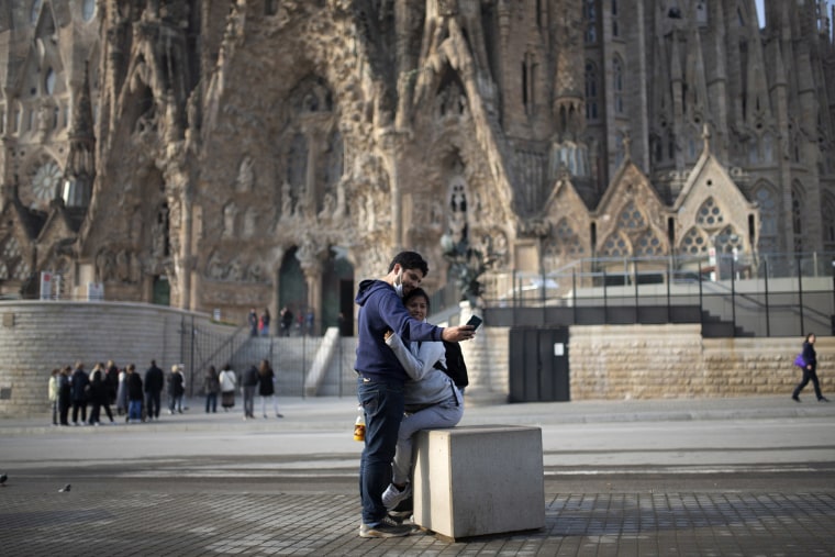 Image: People take a selfie outside the Sagrada Familia basilica in Barcelona, Spain