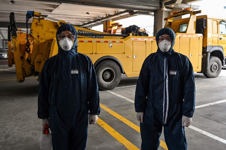 Image: Workers wearing protective gear prepare to disinfect a bus as part of measures against of the COVID-19 coronavirus in Shanghai