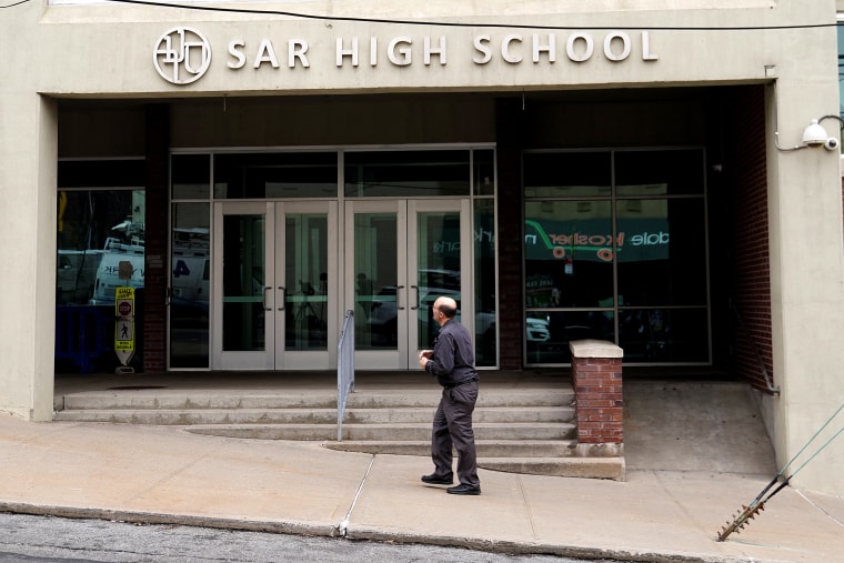 Image: A man walks past SAR High School which has been shut down due to Coronavirus in the Bronx borough of New York City
