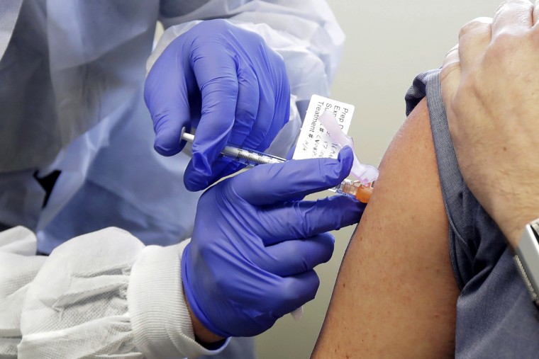 Neal Browning receives a shot in the first-stage safety study clinical trial of a potential vaccine for COVID-19, the disease caused by the new coronavirus, Monday, March 16, 2020, at the Kaiser Permanente Washington Health Research Institute in Seattle. Browning is the second patient to receive the shot in the study.