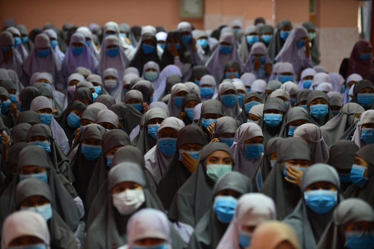 Image: Thai Muslim students wear face masks donated by a school official as a preventive measure against the COVID-19 coronavirus during a ceremony at Attarkiah Islamic School in Thailand's southern province of Narathiwat