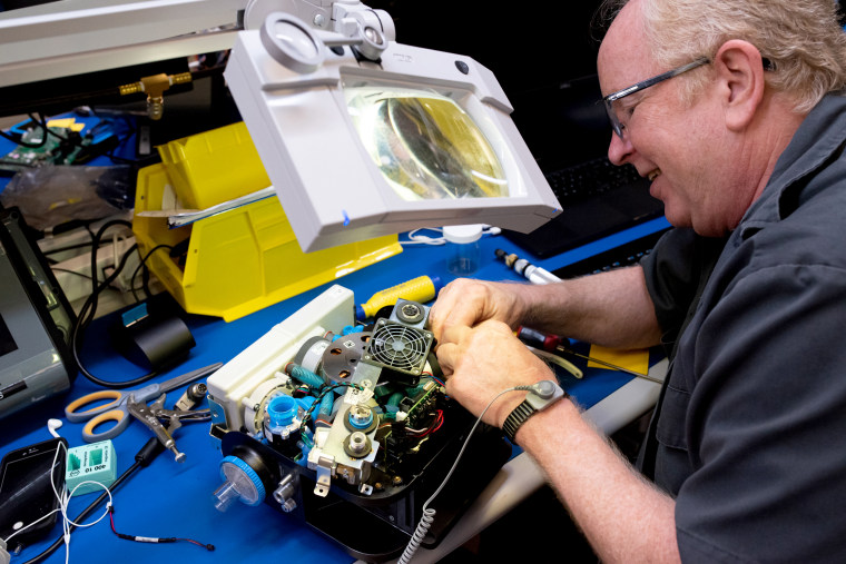 Image: A Ventec Life Systems worker operates on a VOCSN machine, which combines the work of five respiratory medical devices into one.