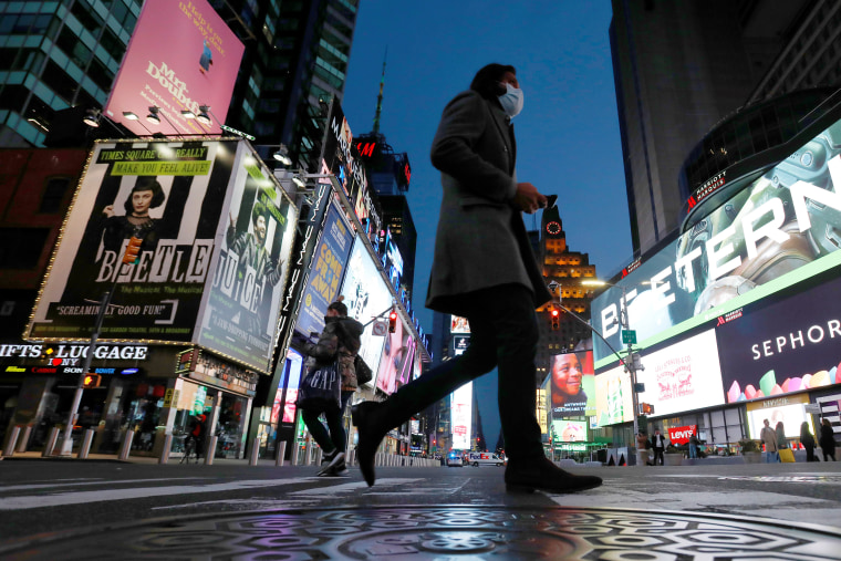 Image: People walk in Times Square as the coronavirus disease (COVID-19) outbreak continues in Manhattan, New York City