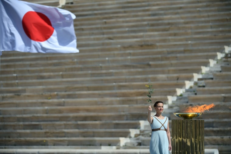 Image: A performer in Athens at the Olympic flame handover ceremony for the 2020 Tokyo Summer Olympics.