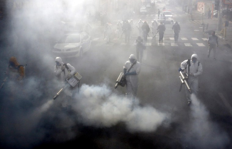 Image: Iranian firefighters disinfect streets in Tehran to slow the spread of coronavirus on March 13, 2020.