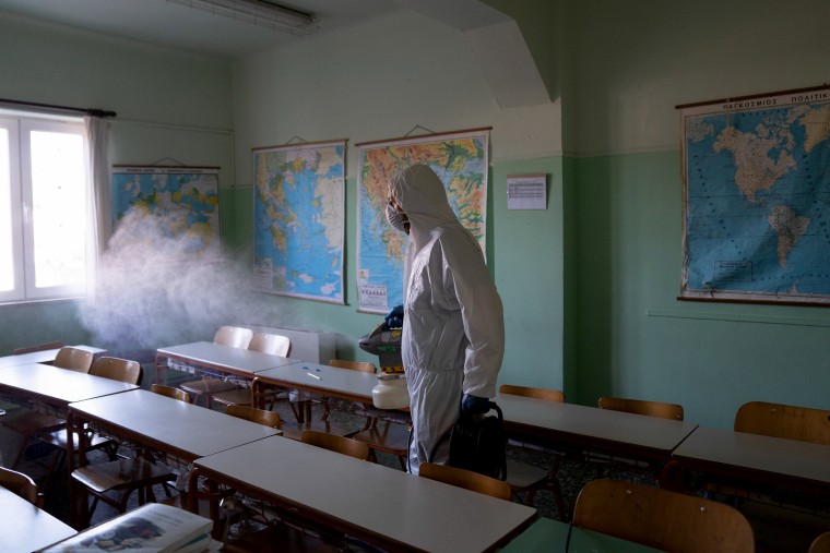 Image: A worker in a protective suit disinfects a classroom at an elementary school in Ioannina, Greece, on March 19, 2020.