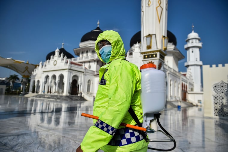 Image: An Indonesian police officer sprays disinfectant in the Baiturrahman grand mosque, amid concerns of the COVID-19 coronavirus, in Banda Aceh