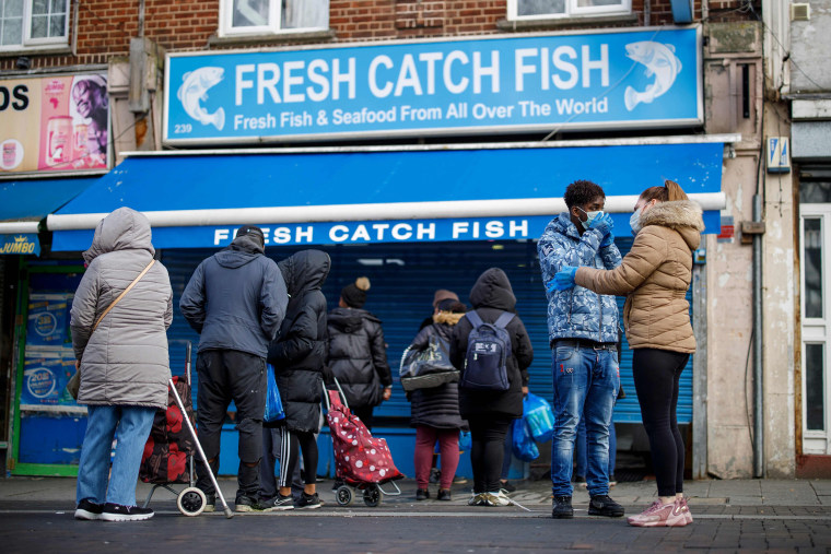 Image: People line up outside a local fishmongers before opening in Walthamstow, east London