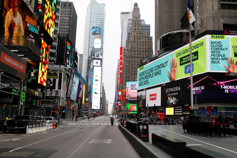 Image: A message about protecting yourself from the coronavirus disease (COVID-19) is seen on an electronic billboard in a nearly empty Times Square