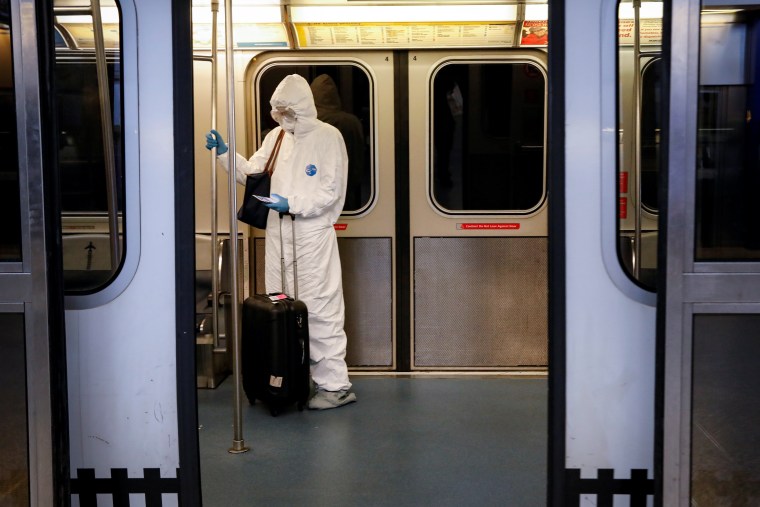 Image: A woman wears personal protective equipment (PPE) as she rides the air-train at John F. Kennedy International Airport in New York