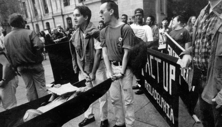 Image: Chris Bartlett, left, and Dominic Piccirelli hold a stretcher carrying a fellow protester at an ACT UP "die in" protest outside Philadelphia's City Hall in 1990.