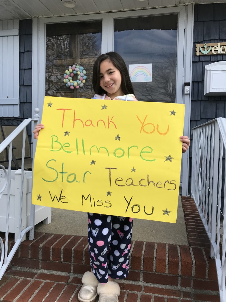 Carla Wong of Bellmore, New York, said her daughter Brooke, 8, misses her friends and teachers now that they are at home in isolation due to the COVID-19 pandemic. She was so excited about seeing her teachers even from a distance that she waited outside i