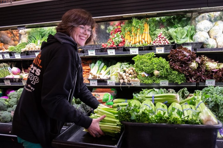 Woman restocking produce at Weavers Way Co-op in Philadelphia