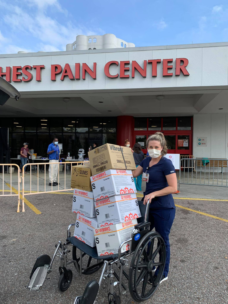 A healthcare worker in Mobile, Alabama, carries boxes of gloves and masks that were donated by local nail salons.