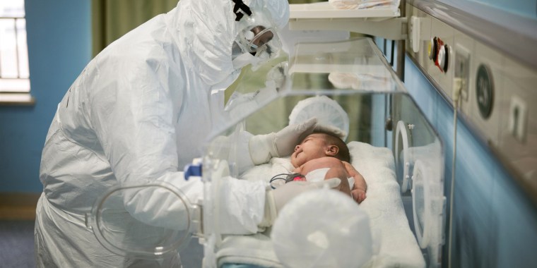 A staff member attends to a baby with coronavirus at the Wuhan Children's Hospital in China on March 6, 2020.