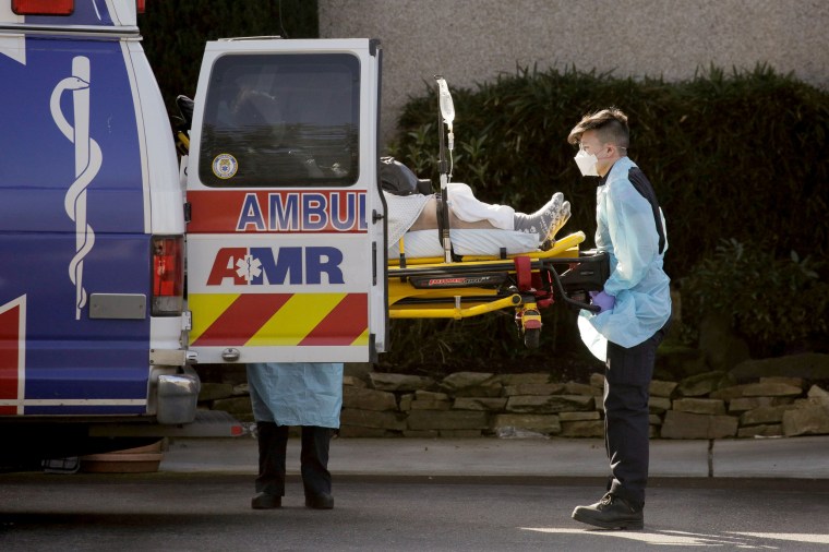 Image: Medics load a patient into an ambulance outside the Life Care Center of Kirkland in Washington on March 4, 2020. The facility is linked to several confirmed coronavirus cases.