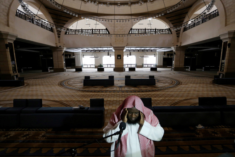 Image: A cleric calls for prayer at an empty mosque on Friday as prayers were suspended following the spread of coronavirus.