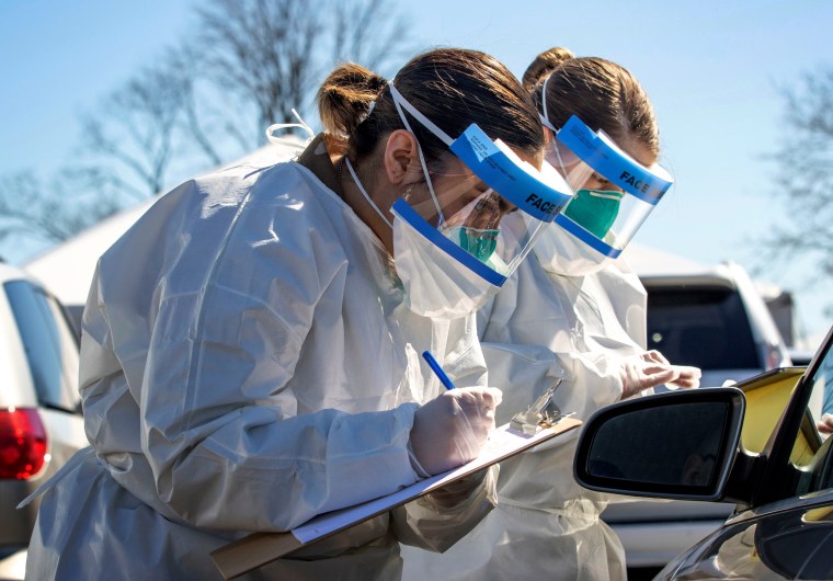 Image: Army Spc. Reagan Long and Pfc. Naomi Velez register people at a coronavirus mobile testing center in New Rochelle, N.Y., on March 14, 2020.