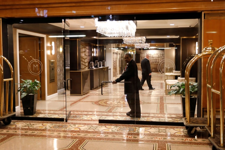 A doorman looks out from an empty hotel lobby in Herald Square in Manhattan during the coronavirus outbreak in New York City on March 18, 2020.