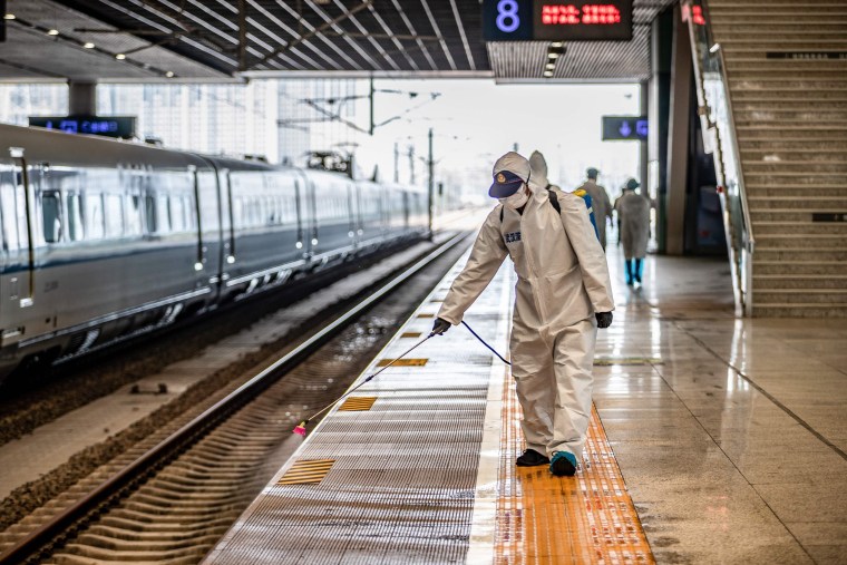 Image: A staff member sprays disinfectant at Wuhan Railway Station in Wuhan in China's central Hubei province