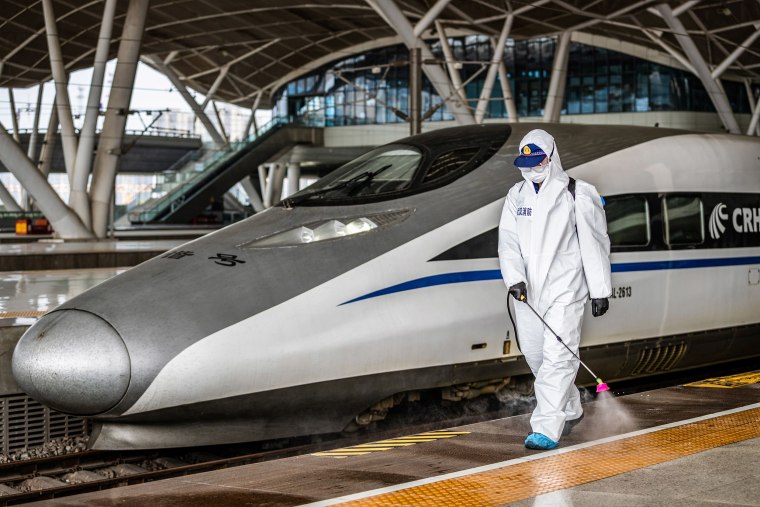 Image: A staff member sprays disinfectant at Wuhan Railway Station in Wuhan in China's central Hubei province