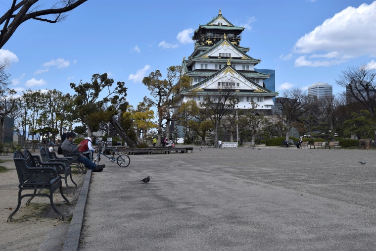 Image: Empty benches and near-deserted walking areas in front of Osaka Castle Main Tower