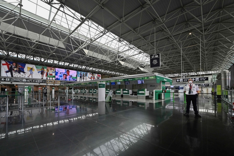 Image: An airport security agent stands guard in a deserted Terminal T1 of Rome's Fiumicino international airport on March 17, 2020, as the T1 is closing and all operations taking place at Terminal T3.