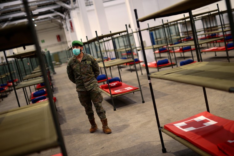A Spanish soldier stands next to beds set up at a temporary hospital in Barcelona on Wednesday.