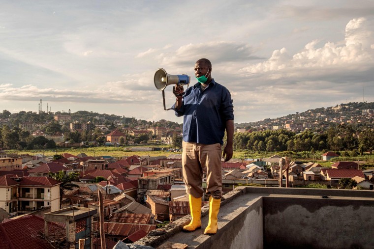 Image: Gonzaga Yiga, a community chairperson in the Ugandan capital of Kampala, speaks from the city's highest building to residents about the coronavirus on March 24, 2020.