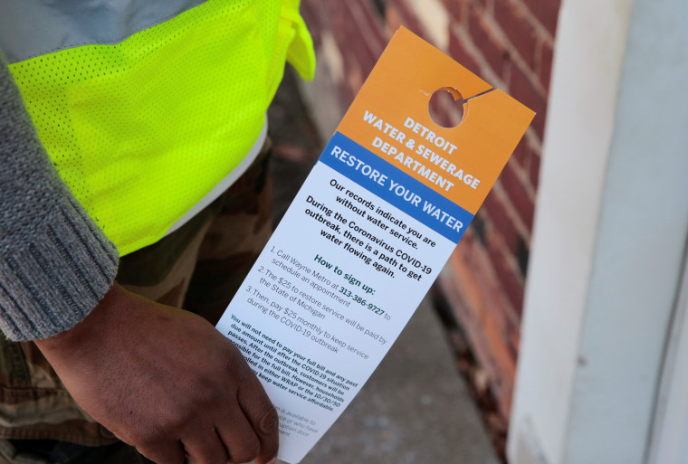 Image: Contract worker Vaughn Harrington holds notices by the Detroit Water and Sewerage Department to inform residents how to restore water service in response to the coronavirus outbreak in Detroit