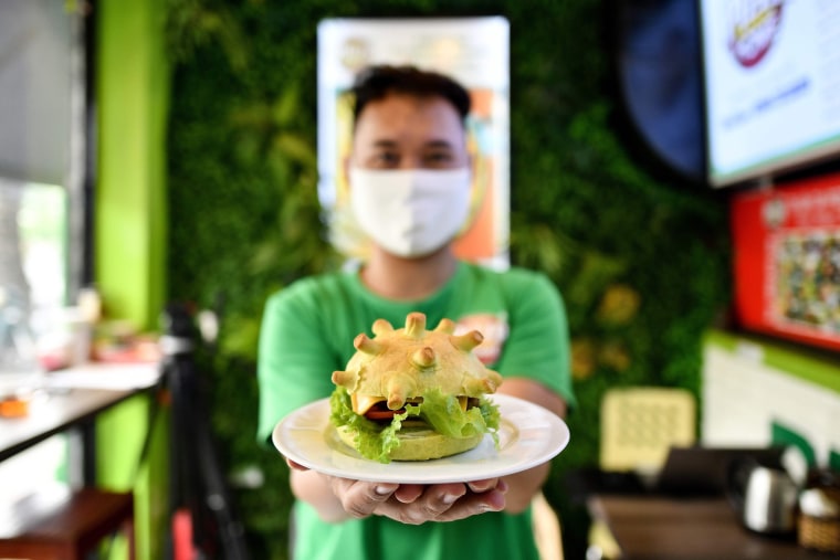 Image: Restaurant owner Hoang Tung shows off a coronavirus-themed burger on Thursday in Hanoi, Vietnam.