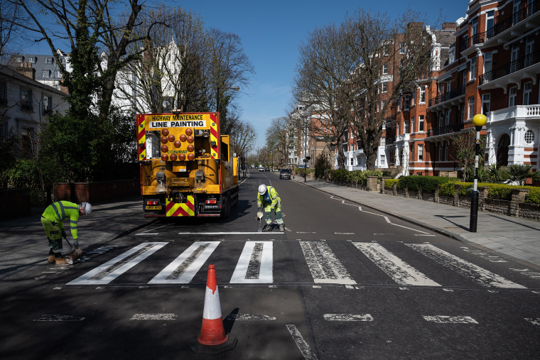 Image: A maintenance team takes advantage of the coronavirus lockdown to re-paint London's iconic Abbey Road crossing.