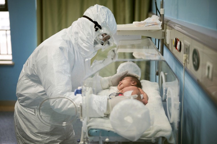 A staff member attends to a baby with coronavirus at the Wuhan Children's Hospital in China on March 6, 2020.