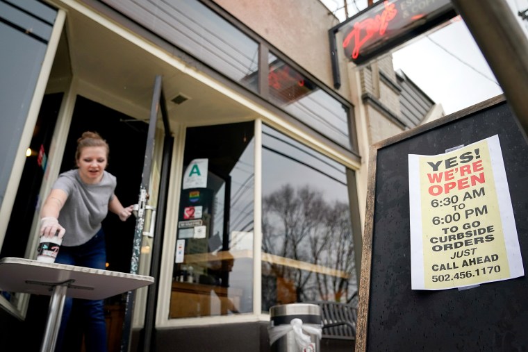 Image: Kayla Marx places an order outside the door of Day's Espresso and Coffee Shop after a state mandated carry-out only policy went into effect in order to slow the spread of the novel coronavirus (COVID-19) in Louisville