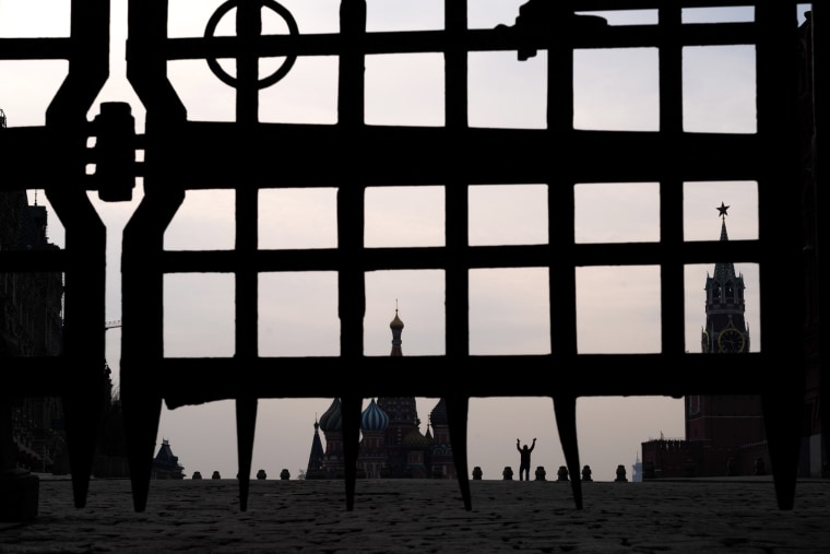 Image: A man gestures in the nearly empty Red Square by St. Basil's Cathedral in Moscow on March 29, 2020.