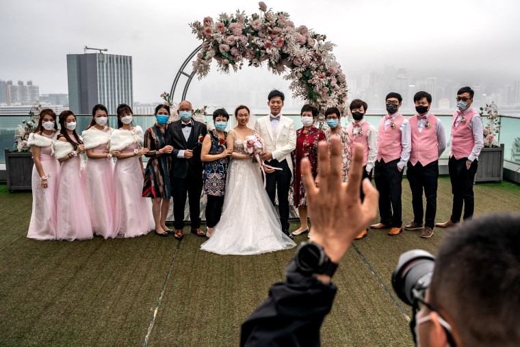 Image: Newlyweds pose for a photo with family and guests and a wedding ceremony in Hong Kong on March 29, 2020.