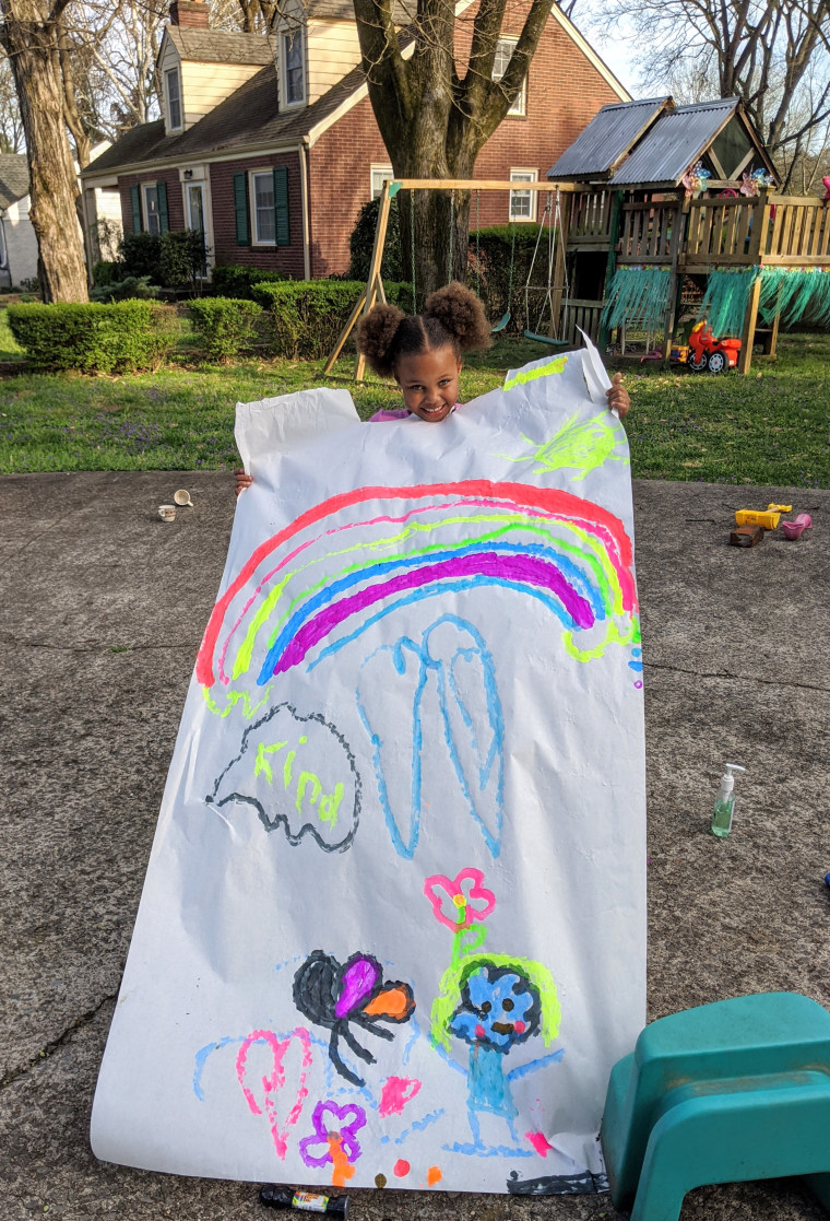 Kira with a drawing she created for her grandparents to look at from across the street.