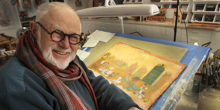 Author Tomie dePaola poses with his artwork in his studio in New London, N.H. on Dec. 1, 2013. His literary agent says dePaola died Monday from surgery complications after taking a bad fall last week.