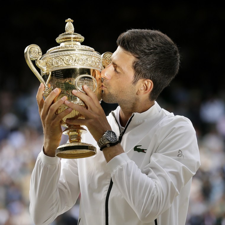 Serbia's Novak Djokovic kisses the trophy after defeating Switzerland's Roger Federer in the men's singles final match of the Wimbledon Tennis Championships in London on July 14, 2019. 