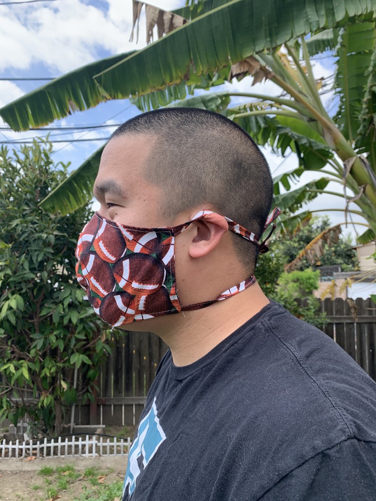 Kevin Pham, Ava Nguyen's boyfriend, wears a mask she made with her mother. 
