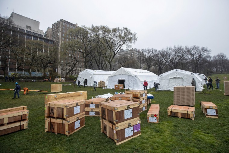 Image: A Samaritan's Purse crew works on building an emergency field hospital equipped with a respiratory unit in New York's Central Park across from the Mount Sinai Hospital